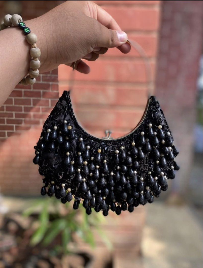 Black Beaded Crescent Evening Handbag (Category: Purses & Pouches) located in Caloocan City. Submitted by cleverwater.ba6482 (Listing ID 1465080575, Image 3). Description: - Color: Elegant black with shimmering beadwork - Design: Crescent shape covered in tiny seed beads and dangling teardrop beads - Closure: Secure metal frame with kiss-lock mechanism - Hardware: Silver top handle - Interior: Clean fabric lining, perfectly sized for small essent