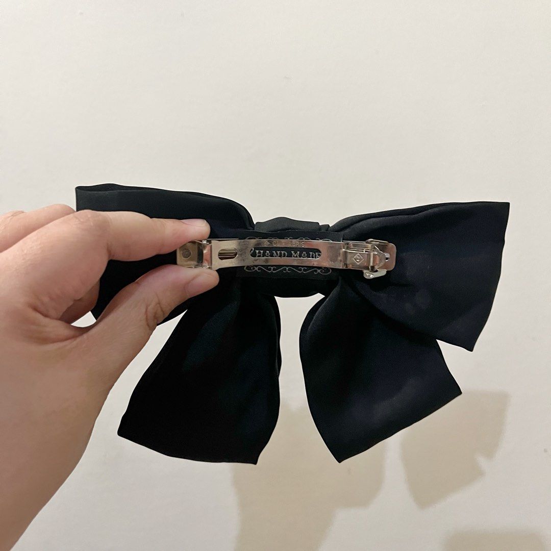 Black Hair Bow Clip Handmade (Category: Hair Accessories) located in San Pedro. Submitted by rainyydayy (Listing ID 1465114824, Image 2). Description: - Color: Classic solid black - Material: High-quality fabric with metal barrette closure - Features: Sturdy and smooth clasp mechanism with handmade lettering stamped on the back - Versatile: Perfect for everyday styles, half-up dos, and matches any outfit.