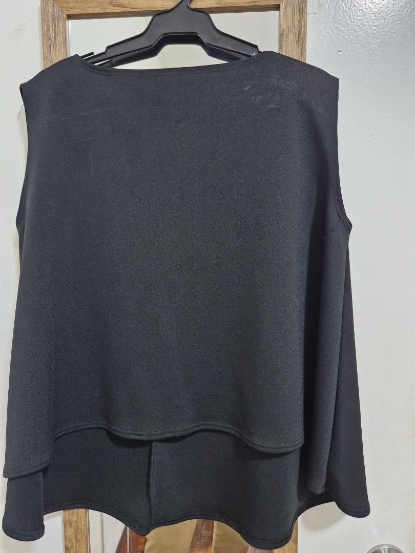 Black layered sleeveless top (Category: Sleeveless) located in San Juan City. Submitted by lss88 (Listing ID 1464971844, Image 1). Description: - Color: Classic Black - Style: Sleeveless top with a structured flared layered design - Neckline: Scoop neck - Hem: Slightly longer back hem (high-low) - Fabric: Holds its structure well, high quality - Versatility: Easy to dress up or down - Pairing: Looks great with slim-fit pants or skirts.