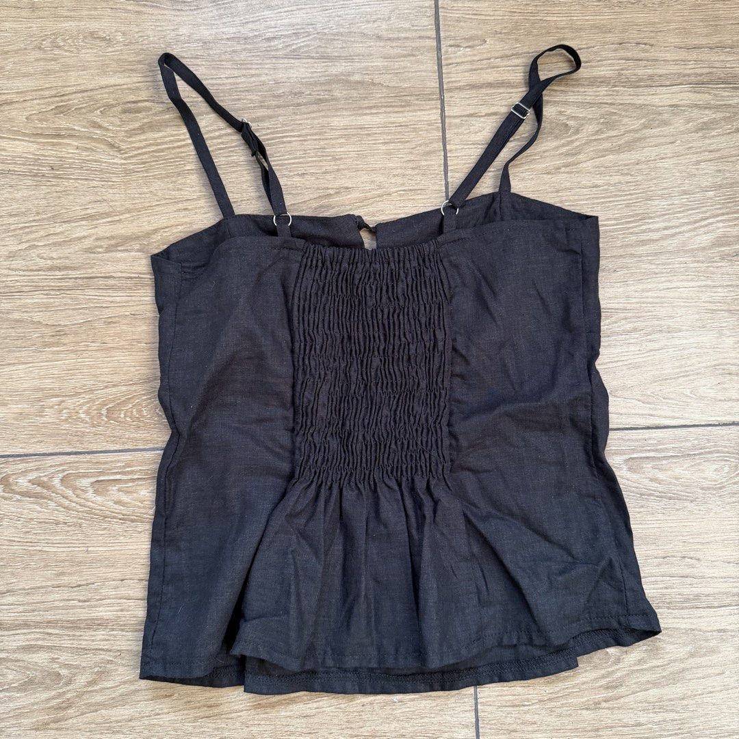 Black linen top with tie front and adjustable straps (Category: Sleeveless) located in Cainta. Submitted by nicsboo (Listing ID 1465087711, Image 3). Description: Bought this from bazaar in estancia around 700+ - Color: Black - Features: Adjustable spaghetti straps, front tie detail, and gathered bust - Comfort: Smocked elastic back panel for extra stretch - Fit: Flared peplum hem - Material: Lightweight and breathable fabric - Condition: Clean a