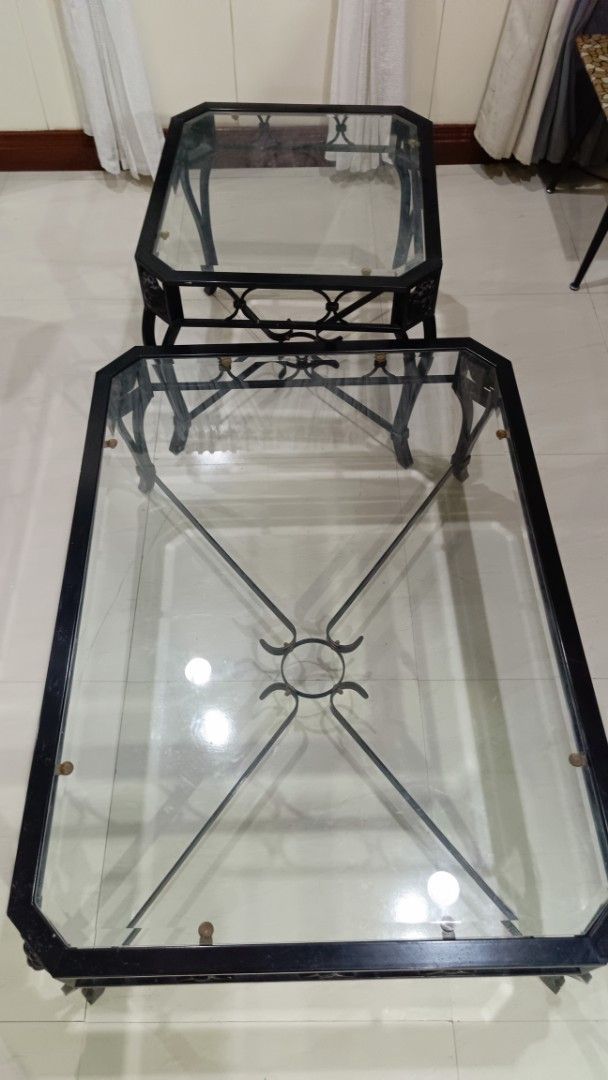 Black Metal Coffee Table with Glass Top (Category: Tables & Sets) located in San Juan City. Submitted by pinkdenxel (Listing ID 1465076445, Image 1). Description: - Set includes: 1 rectangular coffee table and 1 square side table - Design: Black metal frames with glass tops and stylish scrollwork detail - Build: Sturdy, clean, and modern look for any living room - Condition: Selling together as a set - Fulfillment: Pick up only.