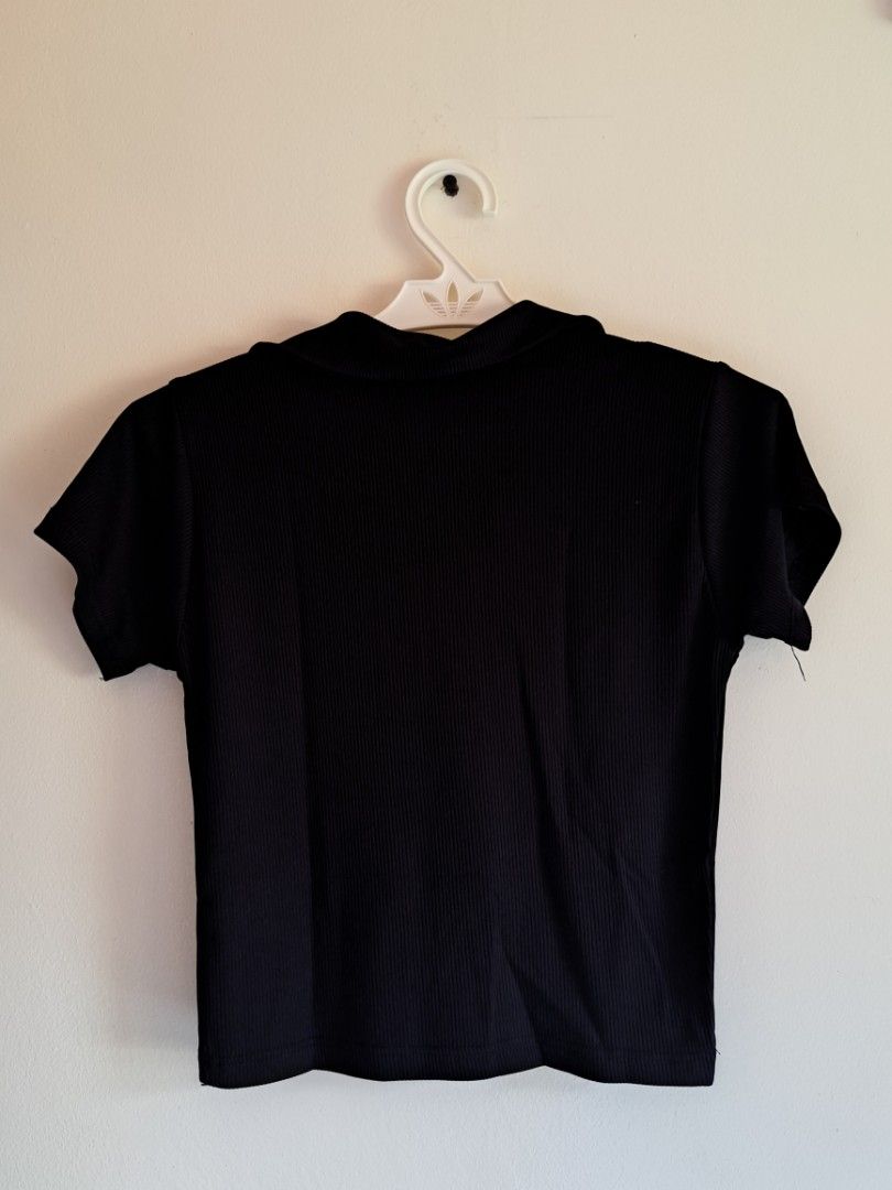 Black Ribbed Collar Crop Top Short Sleeve (Category: Shirts) located in Manila. Submitted by yselles__ (Listing ID 1464979251, Image 2). Description: - Color: Black - Material: Stretchable ribbed knit fabric - Design: Classic collared neckline with open V-neck and short sleeves - Fit: Body-hugging crop top, easy pullover style - Versatility: Perfect for pairing with high-waisted jeans, skirts, or shorts - Condition: Used twice.