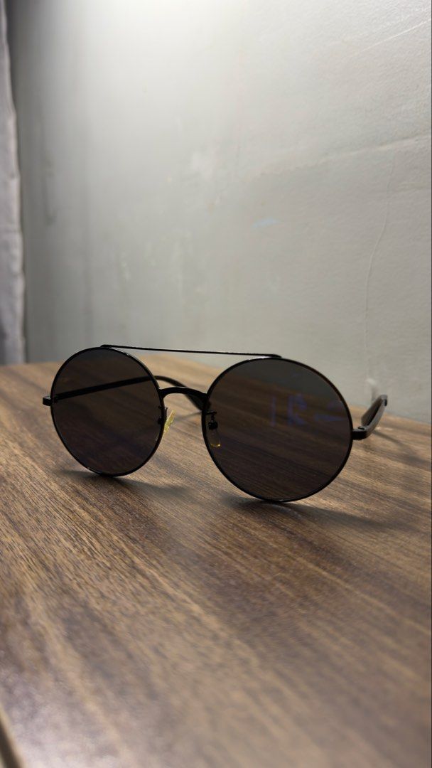 Black Round Frame Sunglasses with Double Bridge (Category: Sunglasses & Eyewear) located in Baguio. Submitted by fndrskprskid (Listing ID 1465124721, Image 2). Description: Black round sunglasses. Thin metal frame with a double brow bar. Dark tinted lenses with a slight blue reflection in certain angles. Adjustable nose pads. Sleek arms with curved tips. Minimalist design, great for everyday wear or sunny days out. Clean condition. - No case - Fl