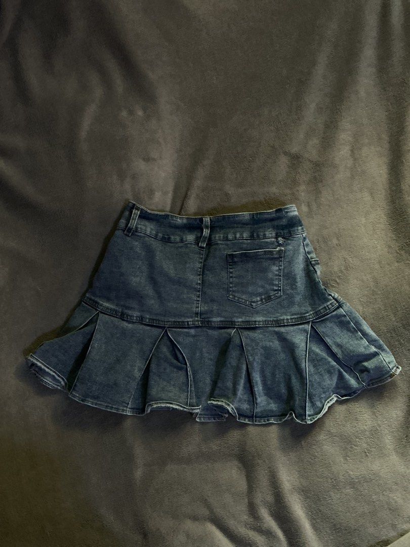 Blue denim pleated miniskirt with pockets (Category: Skirts) located in Manila. Submitted by klokardaxh (Listing ID 1465168554, Image 2). Description: - Color: Dark blue with washed denim texture - Style: Mid-rise miniskirt with a flared pleated hem - Details: Front button and zip fly closure, belt loops - Pockets: Two front pockets and one back right pocket - Finish: Raw, slightly frayed hem edges.
