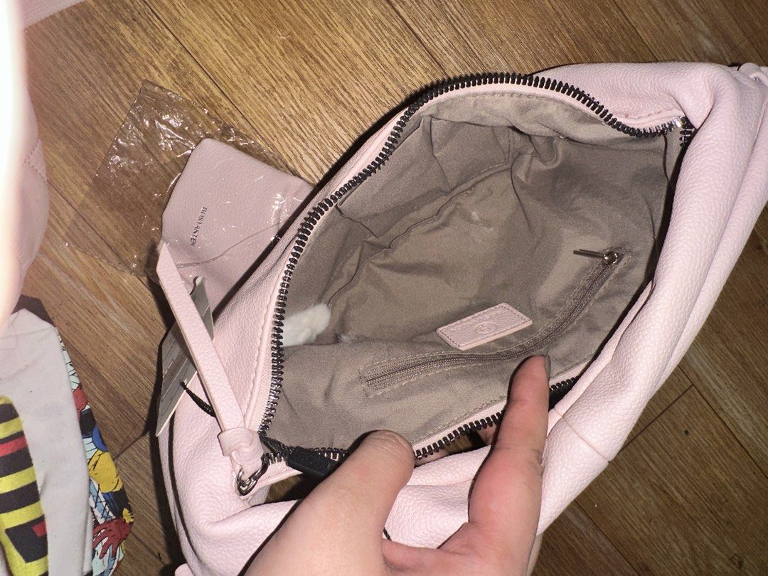 Bostanten Pink Crescent Hobo Bag with Mini Pouch (Category: Shoulder Bags) located in Manila. Submitted by edgiedge (Listing ID 1465032174, Image 3). Description: Bostanten pink crescent hobo bag. Still has the original tag attached. Includes a matching mini drawstring pouch in a separate plastic wrap. Soft textured finish, silver hardware, and a single shoulder strap. Zip closure across the top with fabric-lined interior and zipper pocket inside