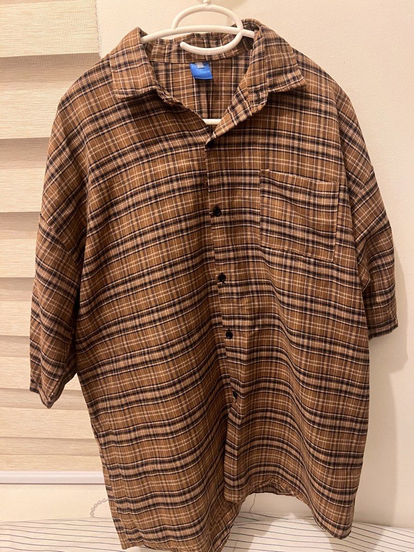 Brown Plaid Button-Down Shirt Oversized (Category: Shirts) located in Las Pinas. Submitted by basicapparel_mnl (Listing ID 1465103617, Image 1). Description: - Style: Brown plaid flannel button-down shirt - Design: Classic collar, dark front buttons, and single chest pocket on the left - Fit & Sleeves: Relaxed fit with comfortable elbow-length sleeves - Versatility: Neutral earth tones that pair easily with jeans or cargo pants - Material: Soft a