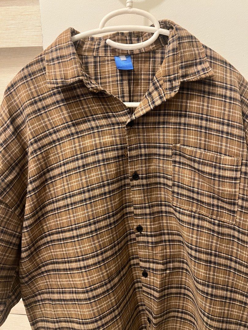 Brown Plaid Button-Down Shirt Oversized (Category: Shirts) located in Las Pinas. Submitted by basicapparel_mnl (Listing ID 1465103617, Image 2). Description: - Style: Brown plaid flannel button-down shirt - Design: Classic collar, dark front buttons, and single chest pocket on the left - Fit & Sleeves: Relaxed fit with comfortable elbow-length sleeves - Versatility: Neutral earth tones that pair easily with jeans or cargo pants - Material: Soft a