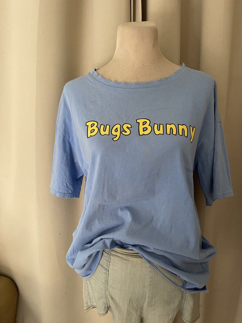 Bugs Football Luck Blue Tee (Category: Shirts) located in Cainta. Submitted by zlove111 (Listing ID 1464970052, Image 3). Description: - Color: Light blue - Design: Bugs Bunny front branding with a large football graphic and 'FOOTBALL LUCK' text on the back - Fit: Relaxed fit with short sleeves - Details: Trendy slightly tattered - Style: Casual everyday top, great for streetwear with minimal washable yellowstain from bale see pic .