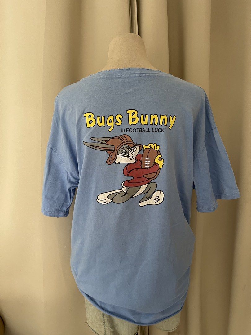 Bugs Football Luck Blue Tee (Category: Shirts) located in Cainta. Submitted by zlove111 (Listing ID 1464970052, Image 1). Description: - Color: Light blue - Design: Bugs Bunny front branding with a large football graphic and 'FOOTBALL LUCK' text on the back - Fit: Relaxed fit with short sleeves - Details: Trendy slightly tattered - Style: Casual everyday top, great for streetwear with minimal washable yellowstain from bale see pic .