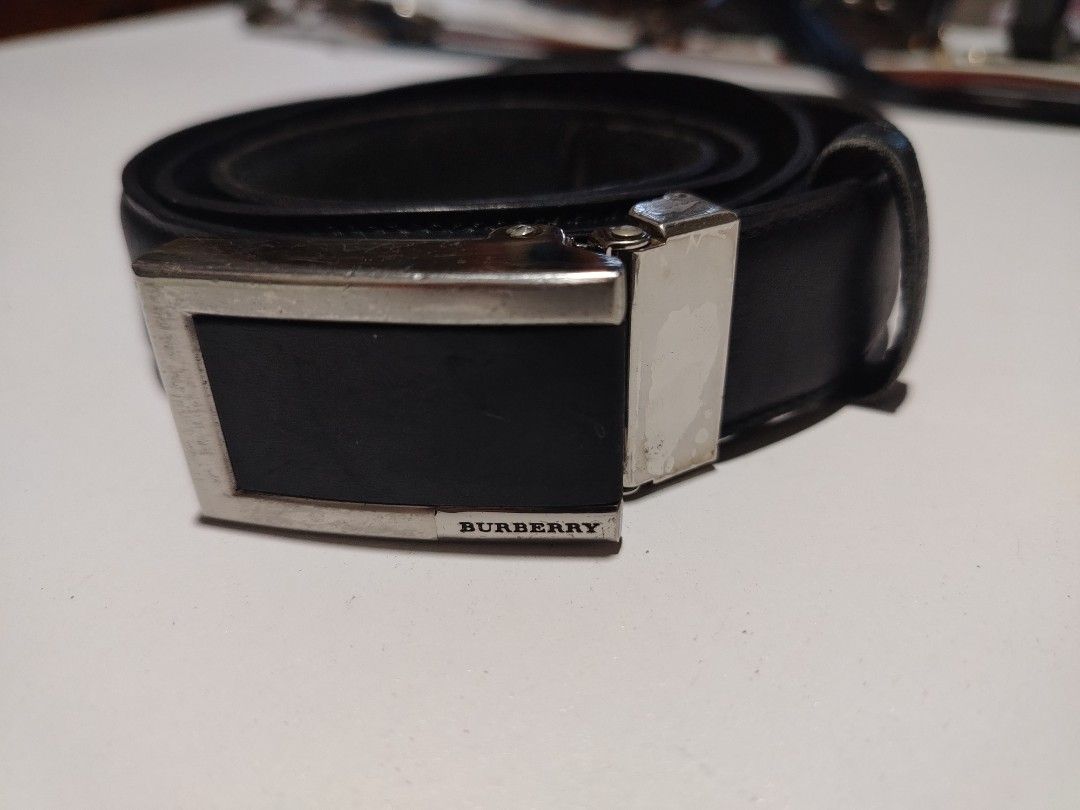 Burberry leather belt (Category: Luxury Accessories) located in Manila. Submitted by rockandrolly (Listing ID 1465107376, Image 1). Description: ✅ Brand: Burberry 🇬🇧 ✅ Material: High-quality smooth black leather ✅ Markings: Engraved BURBERRY on buckle + embossed branding inside strap ✅ Size: ~40" / 102cm — fits 32"–38" waist ✅ Buckle: Classic rectangular auto-lock design ✅ Condition: Pre-owned — leather in good shape; buckle has scratches from 