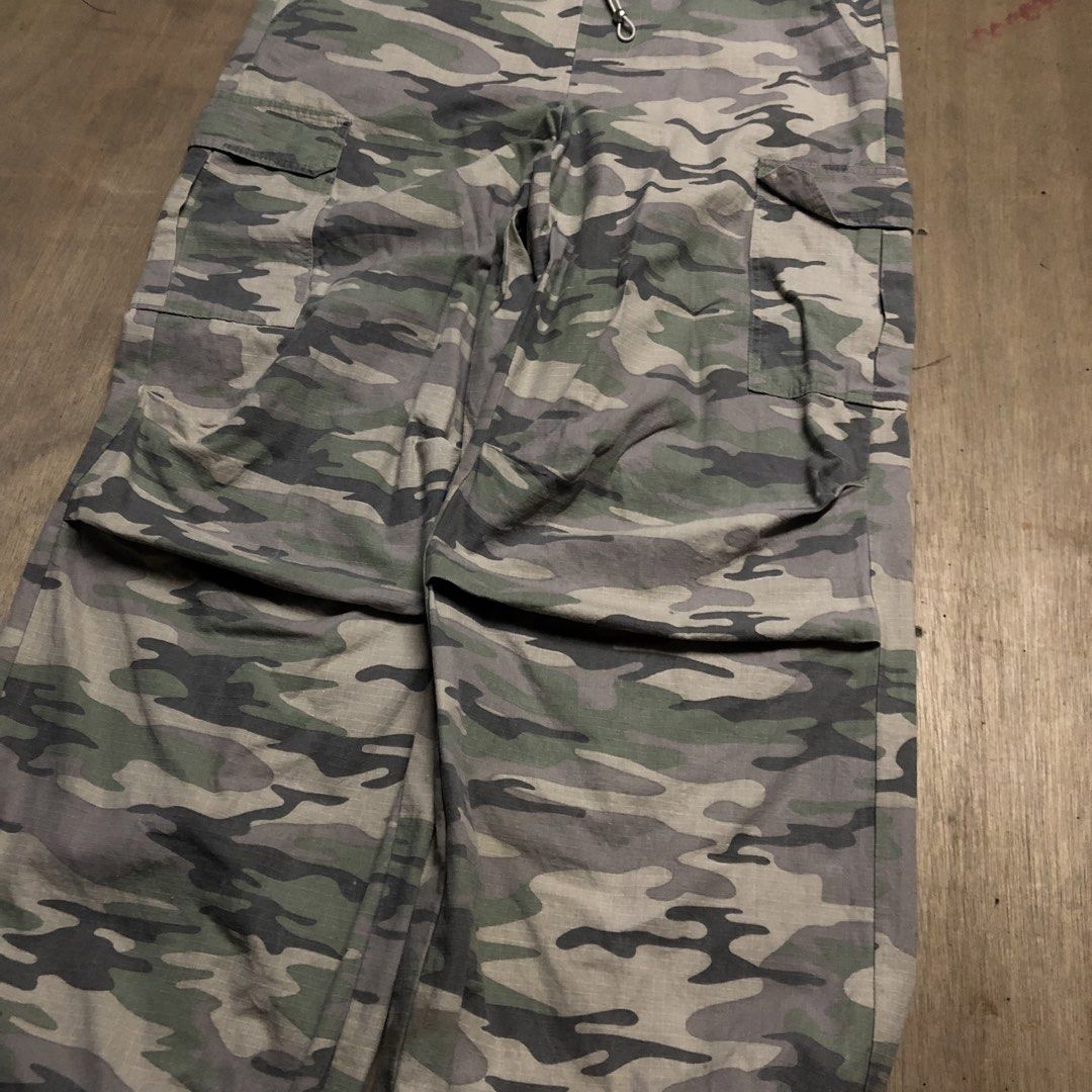 Camo Cargo Pants Drawstring Waist (Category: Joggers) located in Dasmarinas. Submitted by johnlloydm99208 (Listing ID 1465099903, Image 2). Description: - Color: Green and grey camo - Fit: Casual baggy fit, perfect for streetwear - Material: Lightweight ripstop cotton - Features: Utility pockets on both sides, adjustable drawstring waistband, and cinched drawstring cuffs.