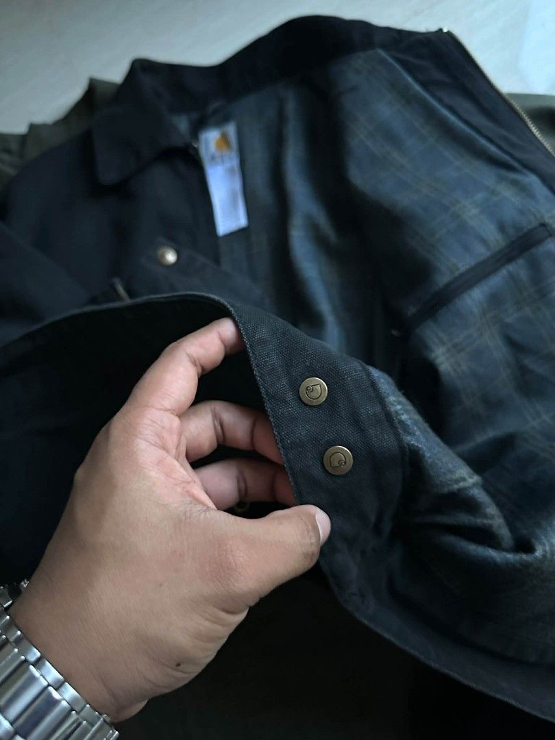 Carhartt J97 PTL Detroit Jacket Medium Regular (Category: Coats, Jackets and Outerwear) located in Santiago. Submitted by PjThrift (Listing ID 1465070318, Image 3). Description: - Brand: Carhartt - Style: Detroit Jacket (J97 PTL) - Color: Black - Size: Medium Regular (23 x 26 dimes) - Lining: Plaid blanket lining - Details: Corduroy collar, brass-tone zipper and buttons, leather logo patch on chest pocket - Condition: Clean canvas fabric, worn li