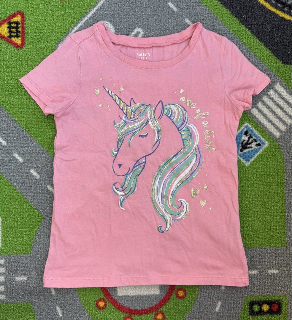Carter's Unicorn T-Shirt (Category: Babies & Kids Fashion) located in Rizal. Submitted by preloovved (Listing ID 1465101355, Image 1). Description: Super cute Carter's pink unicorn t-shirt for kids! Features a glittery 'one of a kind' graphic and soft cotton fabric. Perfect everyday top for little unicorn lovers. From a smoke-free home. Carter’s kids’ pink t-shirt with a unicorn graphic. Features short sleeves, a round neckline, and the words “on