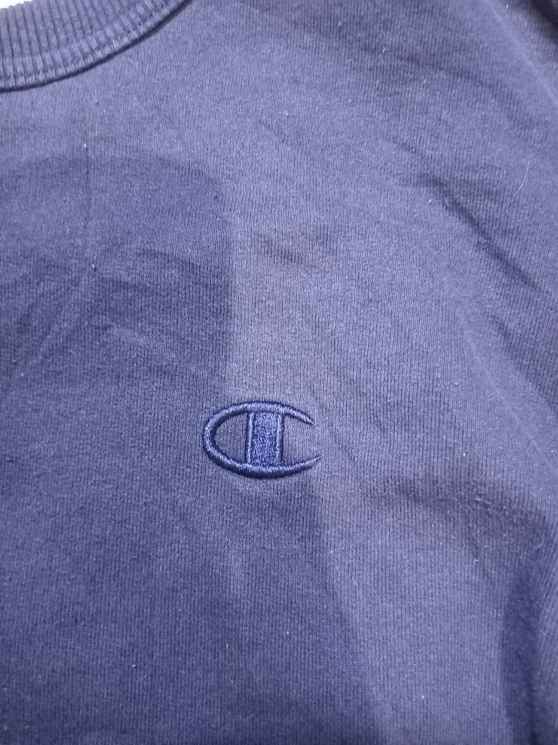 Champion Navy Blue Crewneck Sweatshirt (Category: Coats, Jackets and Outerwear) located in Panabo. Submitted by khimmyirish_ki021126 (Listing ID 1465161845, Image 2). Description: - Brand: Champion - Color: Navy Blue - Size: Medium - Material: Cotton & polyester blend (Made in Honduras) - Design: Embroidered chest logo, logo patch on left wrist, ribbed cuffs, collar, and hem - Condition: Great for casual everyday wear.