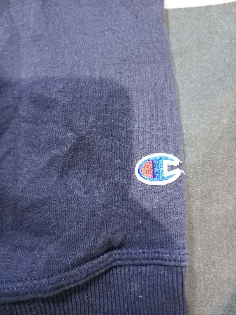 Champion Navy Blue Crewneck Sweatshirt (Category: Coats, Jackets and Outerwear) located in Panabo. Submitted by khimmyirish_ki021126 (Listing ID 1465161845, Image 3). Description: - Brand: Champion - Color: Navy Blue - Size: Medium - Material: Cotton & polyester blend (Made in Honduras) - Design: Embroidered chest logo, logo patch on left wrist, ribbed cuffs, collar, and hem - Condition: Great for casual everyday wear.