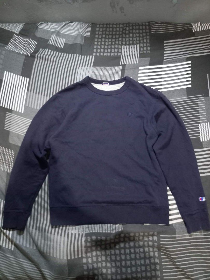 Champion Navy Blue Crewneck Sweatshirt (Category: Coats, Jackets and Outerwear) located in Panabo. Submitted by khimmyirish_ki021126 (Listing ID 1465161845, Image 1). Description: - Brand: Champion - Color: Navy Blue - Size: Medium - Material: Cotton & polyester blend (Made in Honduras) - Design: Embroidered chest logo, logo patch on left wrist, ribbed cuffs, collar, and hem - Condition: Great for casual everyday wear.