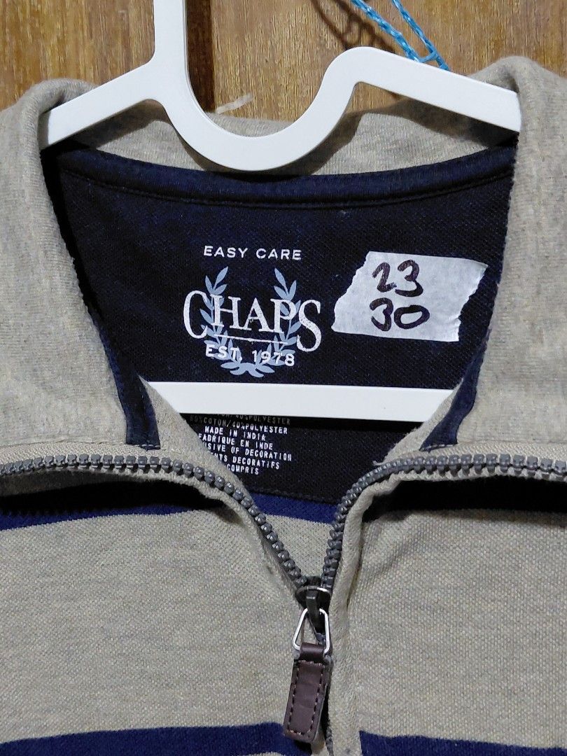 Chaps Striped Quarter-Zip Sweater (Category: Coats, Jackets and Outerwear) located in Imus. Submitted by frootiloots4103 (Listing ID 1464988191, Image 3). Description: - Brand: Chaps - Style: Quarter-zip sweater - Color: Beige with navy blue horizontal stripes - Details: Embroidered chest logo, half-zip closure with leather pull tab, ribbed collar, cuffs, and hem - Material: Cotton and polyester blend (easy care) - Condition: Excellent pre-loved 