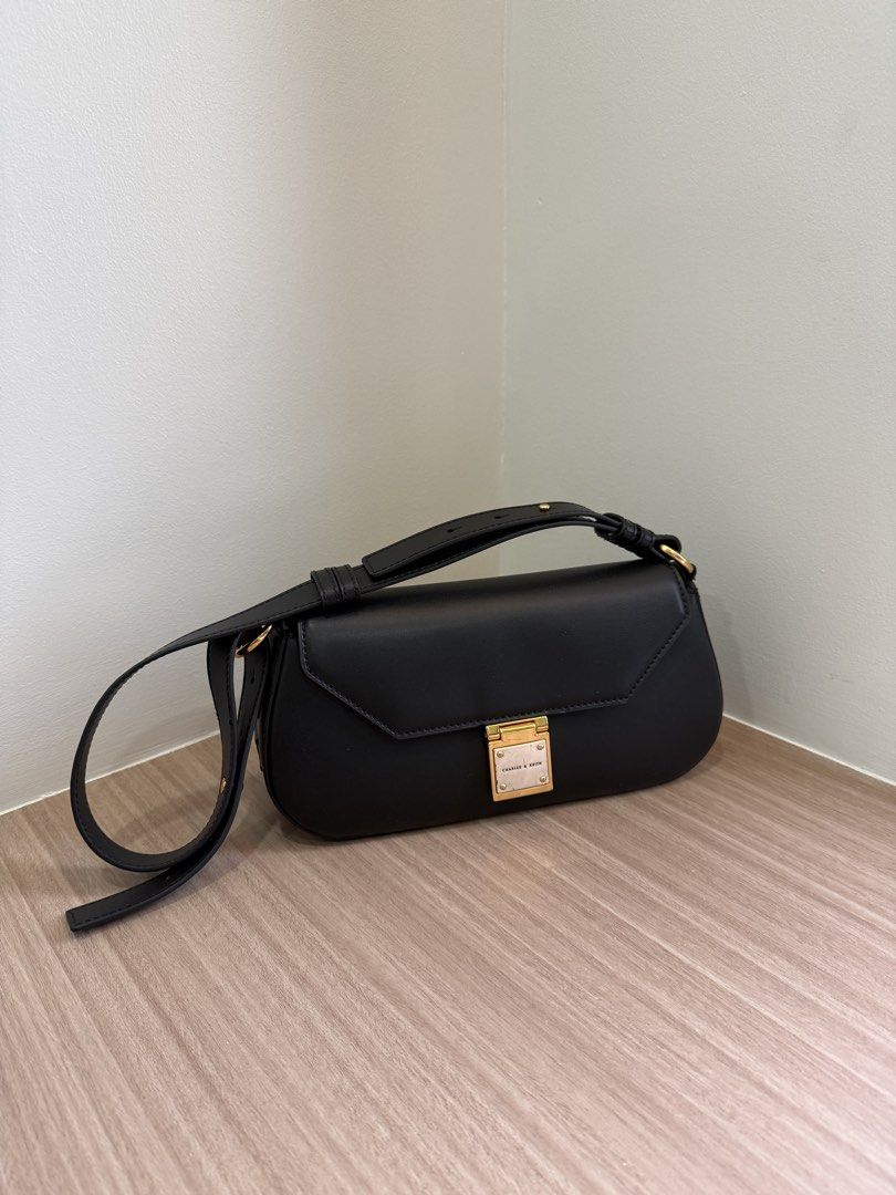 Charles & Keith Black Shoulder Bag (Category: Shoulder Bags) located in Manila. Submitted by elisesnts (Listing ID 1465017768, Image 1). Description: - Brand: Charles & Keith - Color: Classic Black - Style: Structured rectangular shoulder bag with flap closure and adjustable strap - Hardware: Gold-toned metal push-lock buckle with subtle debossed brand lettering - Condition: Clean overall condition with some gasgas on the hardware.