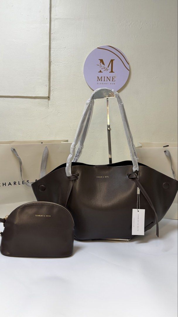 Charles & Keith Dark Brown Tote Bag with Pouch (Category: Tote Bags) located in Manila. Submitted by happydragon_56bba5 (Listing ID 1465083654, Image 1). Description: - Brand: Charles & Keith - Color: Dark brown - Condition: Brand new with retail tag attached, handles still wrapped in original protective foam - Inclusions: Matching zippered pouch and two (2) paper shopping bags - Material: Soft faux leather - Features: Spacious interior, perfect 