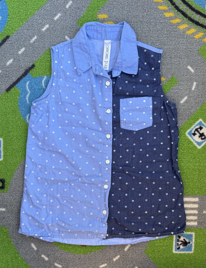 Cherokee Polka Dot Sleeveless Button Down Shirt (Category: Babies & Kids Fashion) located in Rizal. Submitted by preloovved (Listing ID 1465093247, Image 1). Description: Cherokee two-tone sleeveless button-down shirt for kids size 7/8. Features light blue and dark blue panels with white polka dots, a collared neck, and chest pocket. 100% cotton, lightweight and comfortable. Cherokee sleeveless shirt with split design. Features polka dots, collar