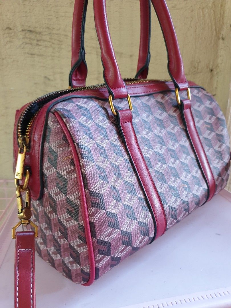 Christy Ng Enzo Duffle Bag (Category: Tote Bags) located in Las Pinas. Submitted by anggesmart (Listing ID 1464972818, Image 2). Description: - Brand: Christy Ng - Design: Burgundy geometric cube pattern with striking red leather trim - Hardware: Premium gold-tone hardware with secure zip closure - Handles & Strap: Dual top handles plus a convenient detachable shoulder strap - Interior: Black fabric-lined with an internal zippered pocket for smal
