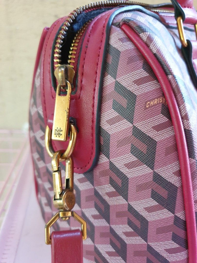 Christy Ng Enzo Duffle Bag (Category: Tote Bags) located in Las Pinas. Submitted by anggesmart (Listing ID 1464972818, Image 3). Description: - Brand: Christy Ng - Design: Burgundy geometric cube pattern with striking red leather trim - Hardware: Premium gold-tone hardware with secure zip closure - Handles & Strap: Dual top handles plus a convenient detachable shoulder strap - Interior: Black fabric-lined with an internal zippered pocket for smal