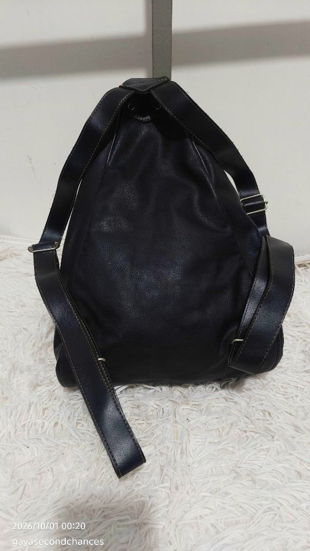 CLASSIC BLACK FAUX LEATHER CONVERTIBLE BACKPACK (Category: Backpacks) located in Kalibo. Submitted by secondchances.thriftsh8p (Listing ID 1465134846, Image 3). Description: - Style: Black faux leather backpack - Condition: Minimal wear on hardware, clean structure and durable stitching - Features: Adjustable shoulder straps, secure zip-around front closure, and snap button flap detail - Versatility: Great everyday size for campus, work, or casua