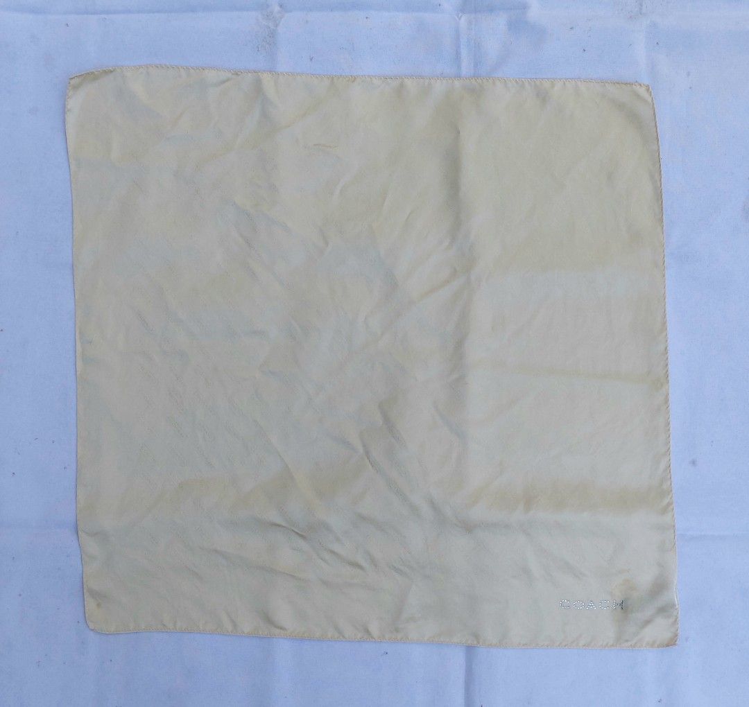 Coach Beige Monogram Silk Scarf with Rhinestone Logo (Category: Scarves) located in Lapu Lapu. Submitted by agnesapm_29813 (Listing ID 1465106411, Image 2). Description: - Brand: Coach - Material: Soft, lightweight silk - Color/Pattern: Pale beige with subtle repeating monogram - Detail: Sparkling crystal rhinestone 'Coach' logo at one corner - Flaw: Small stain, please see last photo - Measurements: 22 x 22 inches .