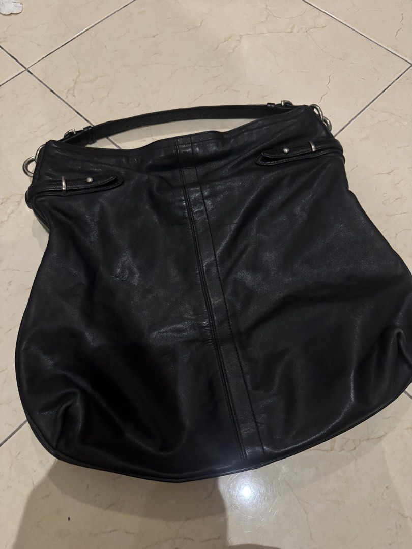 Coach Black Leather Hobo Shoulder Bag (Category: Luxury Bags & Wallets) located in Makati City. Submitted by lumpiawrapper (Listing ID 1465108799, Image 2). Description: - Brand: Coach - Style: Black leather hobo bag with silver hardware - Design: Adjustable strap, buckle details on the sides, and a center vertical leather stripe on the front - Interior: Beautiful light blue satin lining with a zip pocket and slip compartments - Authenticity: Inc