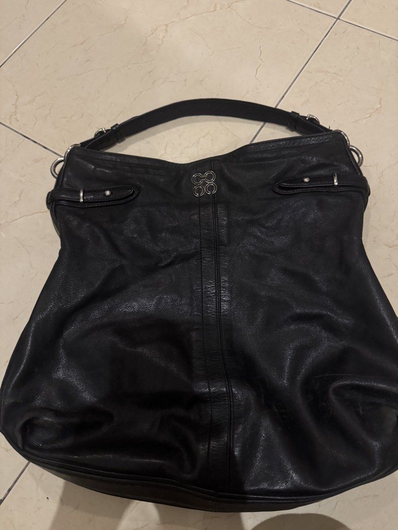 Coach Black Leather Hobo Shoulder Bag (Category: Luxury Bags & Wallets) located in Makati City. Submitted by lumpiawrapper (Listing ID 1465108799, Image 1). Description: - Brand: Coach - Style: Black leather hobo bag with silver hardware - Design: Adjustable strap, buckle details on the sides, and a center vertical leather stripe on the front - Interior: Beautiful light blue satin lining with a zip pocket and slip compartments - Authenticity: Inc