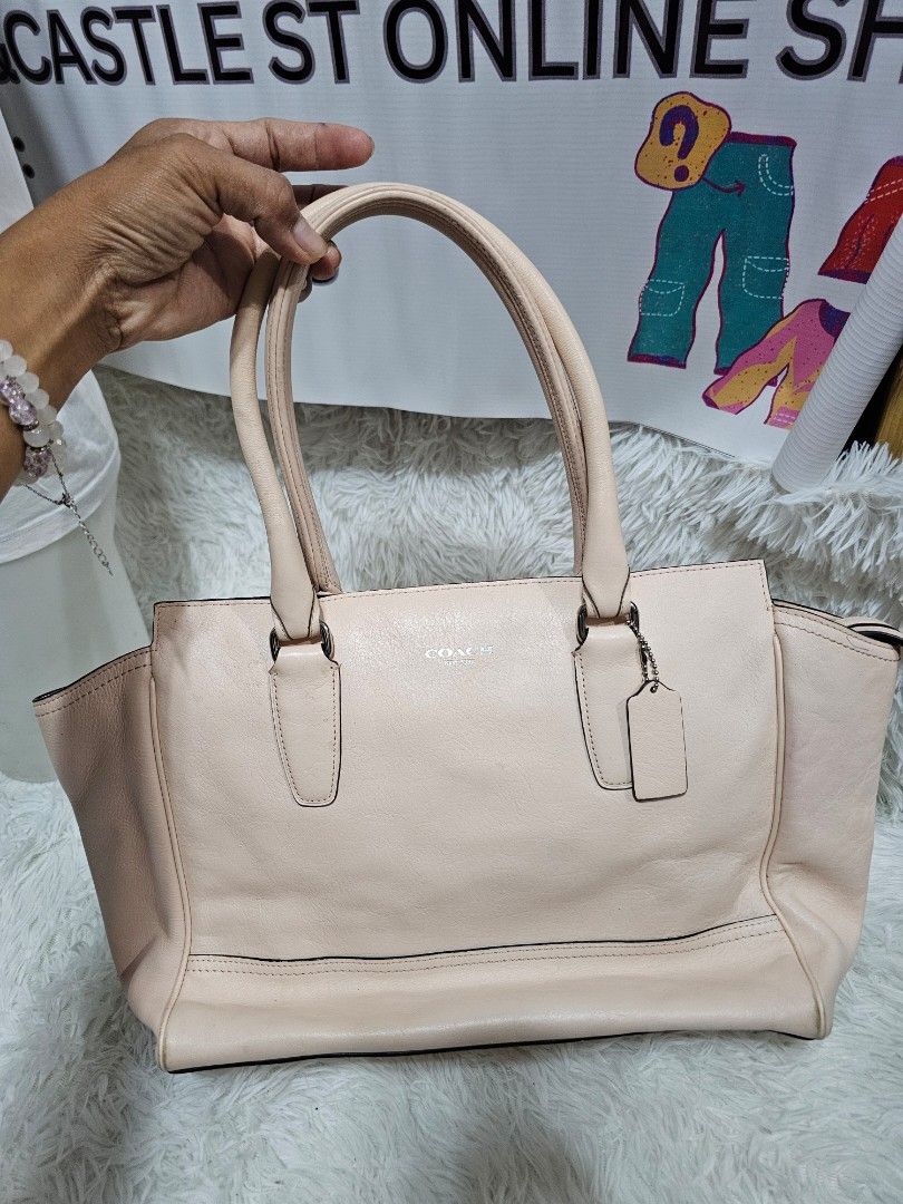 Coach Leather Tote Handbag Peach Pink (Category: Luxury Bags & Wallets) located in Cavite. Submitted by liveriver_514fd1 (Listing ID 1464986359, Image 3). Description: - Brand: Coach - Color: Peach Pink - Material: Genuine Leather - Hardware: Silver-tone - Features: Dual top handles, hanging leather charm tag, and front vertical zipper pocket - Interior: Spacious main compartment for daily essentials - Design: Clean silhouette with subtle front b