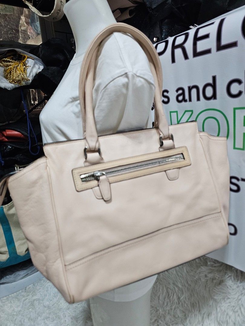 Coach Leather Tote Handbag Peach Pink (Category: Luxury Bags & Wallets) located in Cavite. Submitted by liveriver_514fd1 (Listing ID 1464986359, Image 2). Description: - Brand: Coach - Color: Peach Pink - Material: Genuine Leather - Hardware: Silver-tone - Features: Dual top handles, hanging leather charm tag, and front vertical zipper pocket - Interior: Spacious main compartment for daily essentials - Design: Clean silhouette with subtle front b