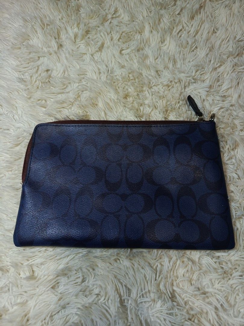 COACH WRISTLET POUCH (Category: Purses & Pouches) located in Baguio. Submitted by 074thriftmania (Listing ID 1465055266, Image 2). Description: - Authentic Coach signature canvas pouch in stylish blue - Dark brown leather front patch with embossed Coach storypatch - Secure top zip closure with silver-tone hardware and built-in D-ring - Clean black fabric interior featuring the official Coach tag - Compact and versatile, ideal as a daily clutch or