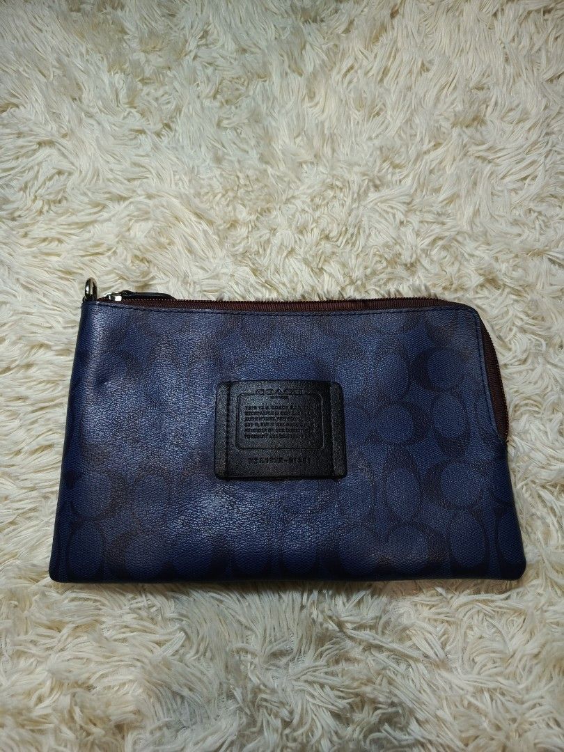 COACH WRISTLET POUCH (Category: Purses & Pouches) located in Baguio. Submitted by 074thriftmania (Listing ID 1465055266, Image 1). Description: - Authentic Coach signature canvas pouch in stylish blue - Dark brown leather front patch with embossed Coach storypatch - Secure top zip closure with silver-tone hardware and built-in D-ring - Clean black fabric interior featuring the official Coach tag - Compact and versatile, ideal as a daily clutch or
