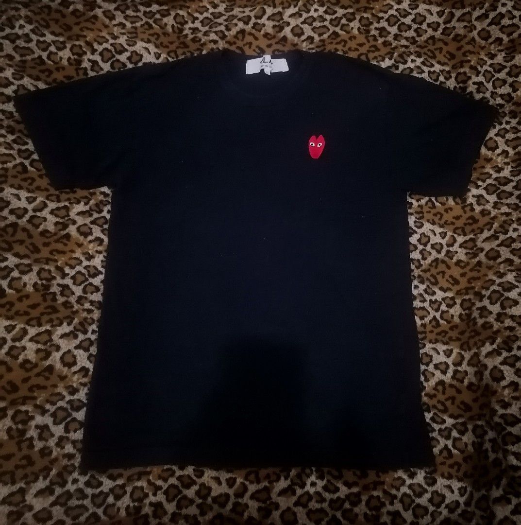 COMME des GARÇONS PLAY Black Heart Tee (Category: Shirts) located in Cebu City. Submitted by roadthrift (Listing ID 1465118806, Image 1). Description: - Brand: Comme des Garçons Play - Color: Black - Size: Large (Measures approx. 21" across) - Material: 100% Cotton - Design: Iconic embroidered red heart logo on chest, classic crew neck, short sleeves - Condition: Clean neck tags and interior care labels intact.