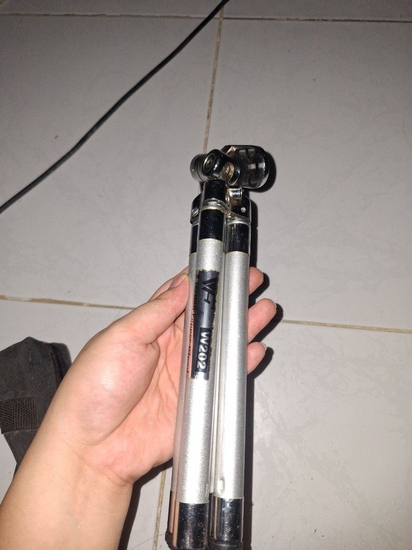 Compact silver metal camera tripod with pan head handle (Category: Tripods & Monopods) located in Manila. Submitted by ogbacsandr04531 (Listing ID 1465100626, Image 1). Description: - Color: Silver and black metal finish - Features: Three extendable legs and adjustable pan head with handle - Compatibility: Standard mounting screw fits most cameras - Portability: Lightweight, collapses compactly, and includes a black fabric carrying case - Best fo