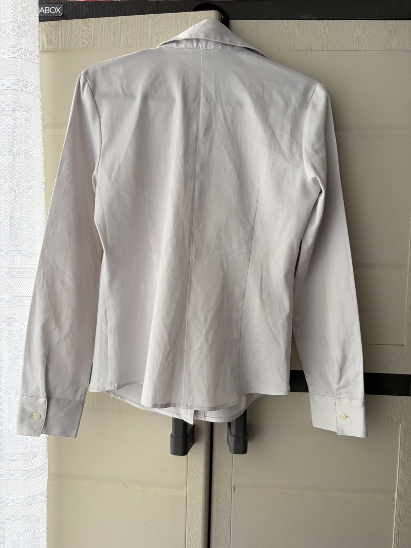 Cosa de Ver Light Gray Office Siren Long Sleeve Button Down Blouse (Category: Longsleeves) located in Dasmarinas. Submitted by prelovedbyxai (Listing ID 1464992386, Image 3). Description: - Brand: Cosa de Ver - Color: Light Gray - Size: XS-S frames - Fabric: High quality, soft, kinda stretchy with a smooth finish - Style: Standard office wear (office siren) or as a smart casual top, gives you flattering fitted silhouette - Condition: No other fla