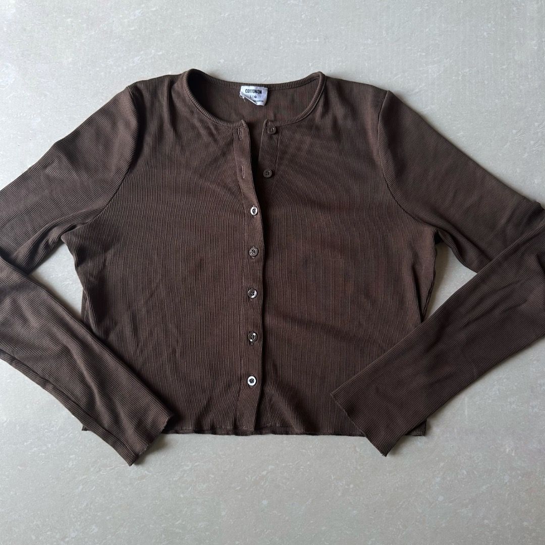 Cotton On Brown Button-Up Cardigan (Category: Coats, Jackets and Outerwear) located in Paranaque City. Submitted by yanie.ae (Listing ID 1464984632, Image 1). Description: - Color: Dark brown - Material: Soft and stretchy ribbed knit - Fit: Size Small (tag inside collar) - Design: Round neckline, front button-down closure, cropped length - Condition: Great for everyday styling and layering.