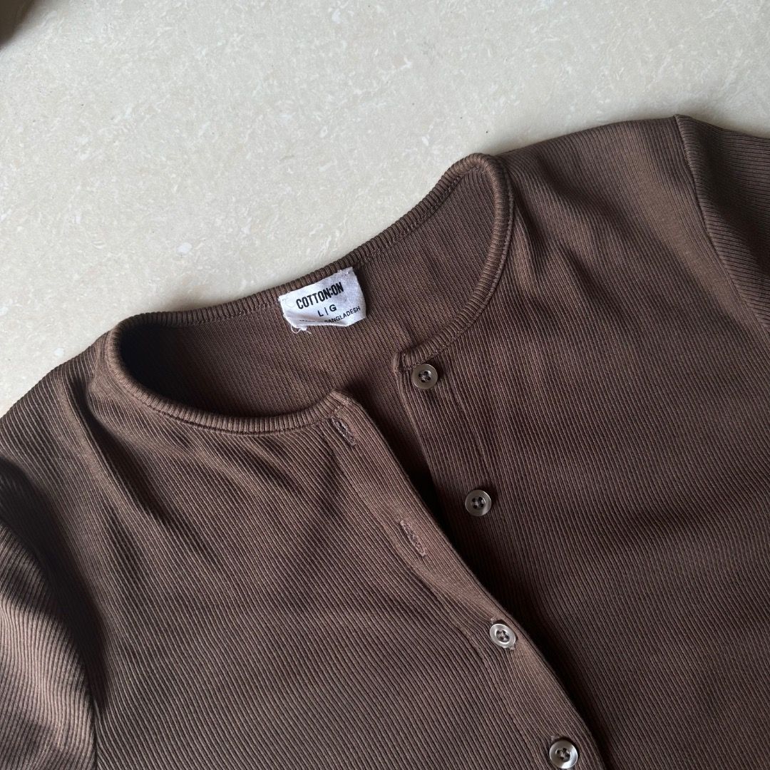 Cotton On Brown Button-Up Cardigan (Category: Coats, Jackets and Outerwear) located in Paranaque City. Submitted by yanie.ae (Listing ID 1464984632, Image 2). Description: - Color: Dark brown - Material: Soft and stretchy ribbed knit - Fit: Size Small (tag inside collar) - Design: Round neckline, front button-down closure, cropped length - Condition: Great for everyday styling and layering.