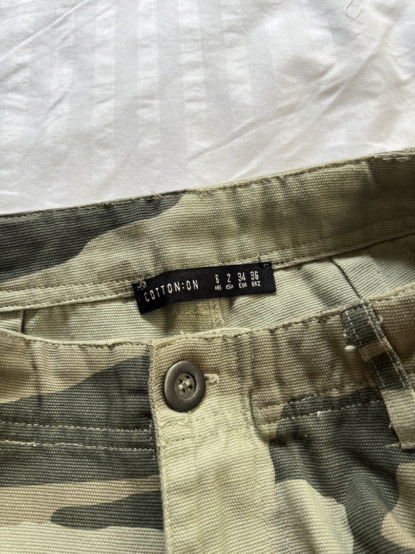 Cotton On Camo Cargo Pants Size 2 / AUS 6 (Category: Jeans) located in Manila. Submitted by tidymarket (Listing ID 1464996887, Image 2). Description: - Brand: Cotton On - Design: Green and beige camo print with raw hems - Fit: Women's AUS size 6 / US size 2, mid-rise waist, straight-leg cut - Details: Button fly and multiple functional thigh utility pockets - Material: 100% cotton fabric.