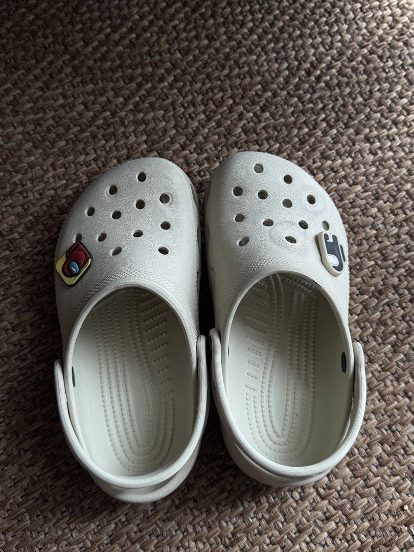Crocs Classic Clogs Off White Cream with Jibbitz (Category: Babies & Kids Fashion) located in Manila. Submitted by veeroonniiccaa (Listing ID 1465057315, Image 3). Description: - Size: Kids J1 - Color: Off-white - Origin: Made in Vietnam - Extras: Includes 2 Among Us Jibbitz charms (Red & Black) - Features: Slip-on style with pivoting heel straps - Condition: Clean overall, ready to wear with light wear on bottom tread.