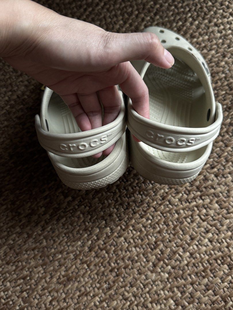 Crocs Classic Clogs Off White Cream with Jibbitz (Category: Babies & Kids Fashion) located in Manila. Submitted by veeroonniiccaa (Listing ID 1465057315, Image 2). Description: - Size: Kids J1 - Color: Off-white - Origin: Made in Vietnam - Extras: Includes 2 Among Us Jibbitz charms (Red & Black) - Features: Slip-on style with pivoting heel straps - Condition: Clean overall, ready to wear with light wear on bottom tread.