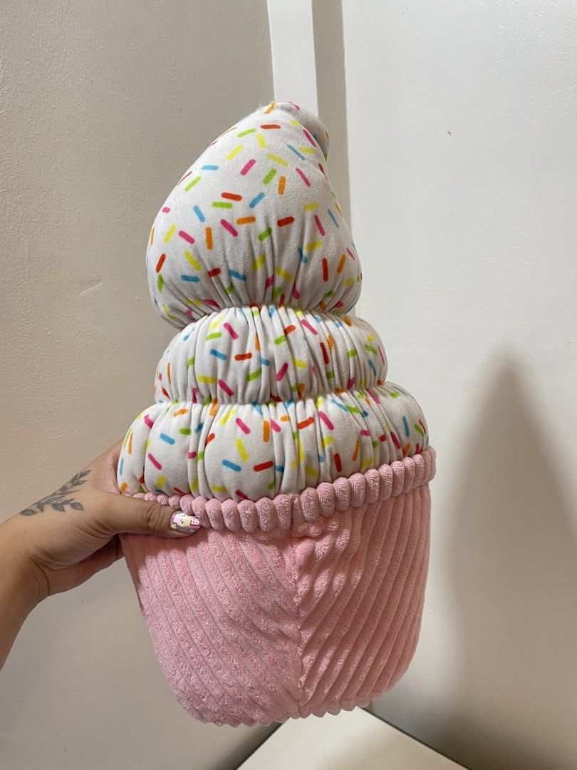Cupcake Ice Cream Cone Plush Pillow Toy (Category: Plushies & Soft Toys) located in Iba. Submitted by wealtheallymari99 (Listing ID 1465047085, Image 2). Description: - Adorable cupcake and ice cream cone plush toy - White top with colorful sprinkles and pink ribbed base - Features cute embroidered face with big black eyes and a smile - Height: approximately tall - Flaw: Small tear near the very top tip, needs a quick stitch.