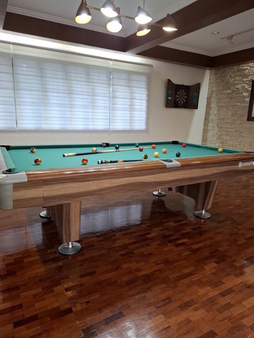Custom Brunswick Billiards Table with Wood Grain Finish (Category: Billiards and Bowling) located in Manila. Submitted by petereye (Listing ID 1465043581, Image 1). Description: -Purchased in 2021 - Custom Brunswick billiards table featuring a stylish wood grain finish and classic green felt - Includes pool cues, extensions, master brand chalk. - Heavy-duty, durable construction equipped with adjustable metal feet for leveling -Andy cloth used fo