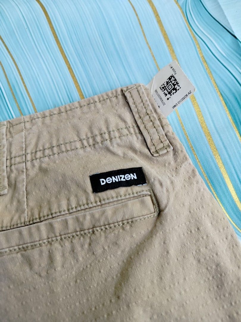 Denizen from Levi's Khaki Cargo Shorts Size 40 (Category: Shorts) located in Manila. Submitted by geraldquinto_917 (Listing ID 1464979128, Image 2). Description: - Brand: Denizen from Levi's - Style: Khaki cargo shorts with textured fabric - Size: 40 - Features: Multiple pockets, including secure zippered side cargo pockets, button closure, and zipper fly - Condition: Pre-loved with some stains on the front leg area (please check photos).