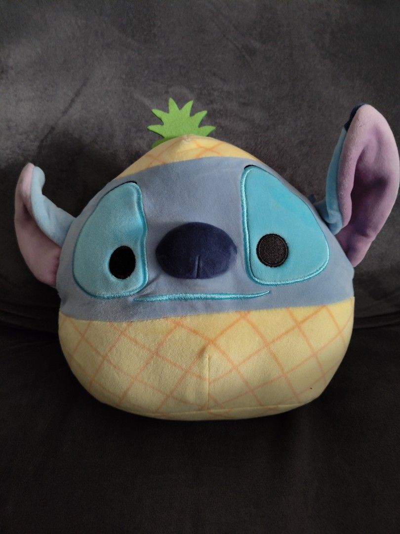 Disney Stitch Pineapple Squishmallows Plush (Category: Plushies & Soft Toys) located in Manila. Submitted by youngcrystal_063c61 (Listing ID 1465020122, Image 1). Description: - Adorable Disney Stitch plush dressed up in a fun pineapple costume - Features Stitch's signature blue face and ears with a yellow textured body and green felt leaves - Soft, huggable material and squeezable shape - Clean surface, no stains or damage spotted - Perfect addi