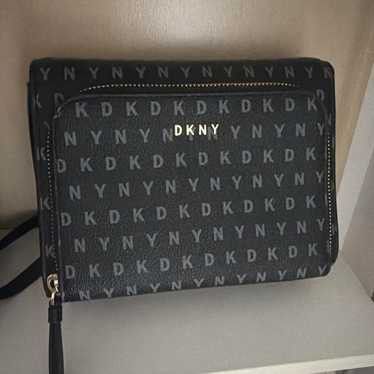 DKNY monogram crossbody bag black (Category: Luxury Bags & Wallets) located in Manila. Submitted by hellocaea010894 (Listing ID 1465115431, Image 1). Description: Black DKNY crossbody bag with all-over DKNY monogram print. Gold hardware lettering on the front pocket. Zip closure with a tassel pull. Long strap with chain detail near the links. Structured rectangular shape with front pocket compartment. Neutral dark tones match casual daily outfits