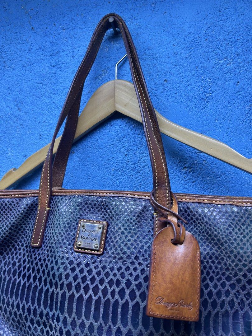 Dooney & Bourke Python Print Leather Tote Bag (Category: Luxury Bags & Wallets) located in Quezon City. Submitted by thriftxgoods (Listing ID 1465078547, Image 2). Description: - Authentic Dooney & Bourke tote bag - Blue-purple python snakeskin embossed leather with tan leather straps and trim - Exterior back zipper pocket and metal brand logo plate - Vibrant red fabric lining with multiple interior slip and zip pockets - Sturdy structured base, 