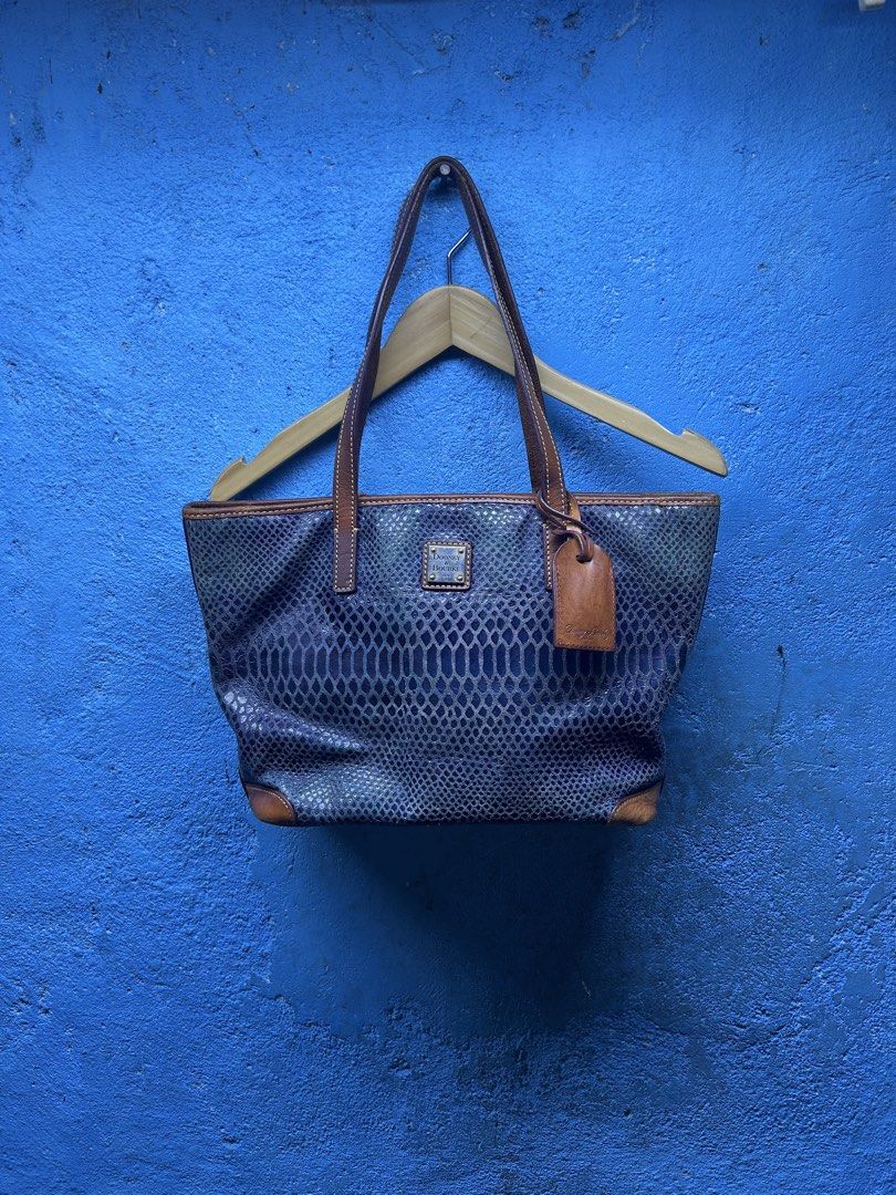 Dooney & Bourke Python Print Leather Tote Bag (Category: Luxury Bags & Wallets) located in Quezon City. Submitted by thriftxgoods (Listing ID 1465078547, Image 1). Description: - Authentic Dooney & Bourke tote bag - Blue-purple python snakeskin embossed leather with tan leather straps and trim - Exterior back zipper pocket and metal brand logo plate - Vibrant red fabric lining with multiple interior slip and zip pockets - Sturdy structured base, 