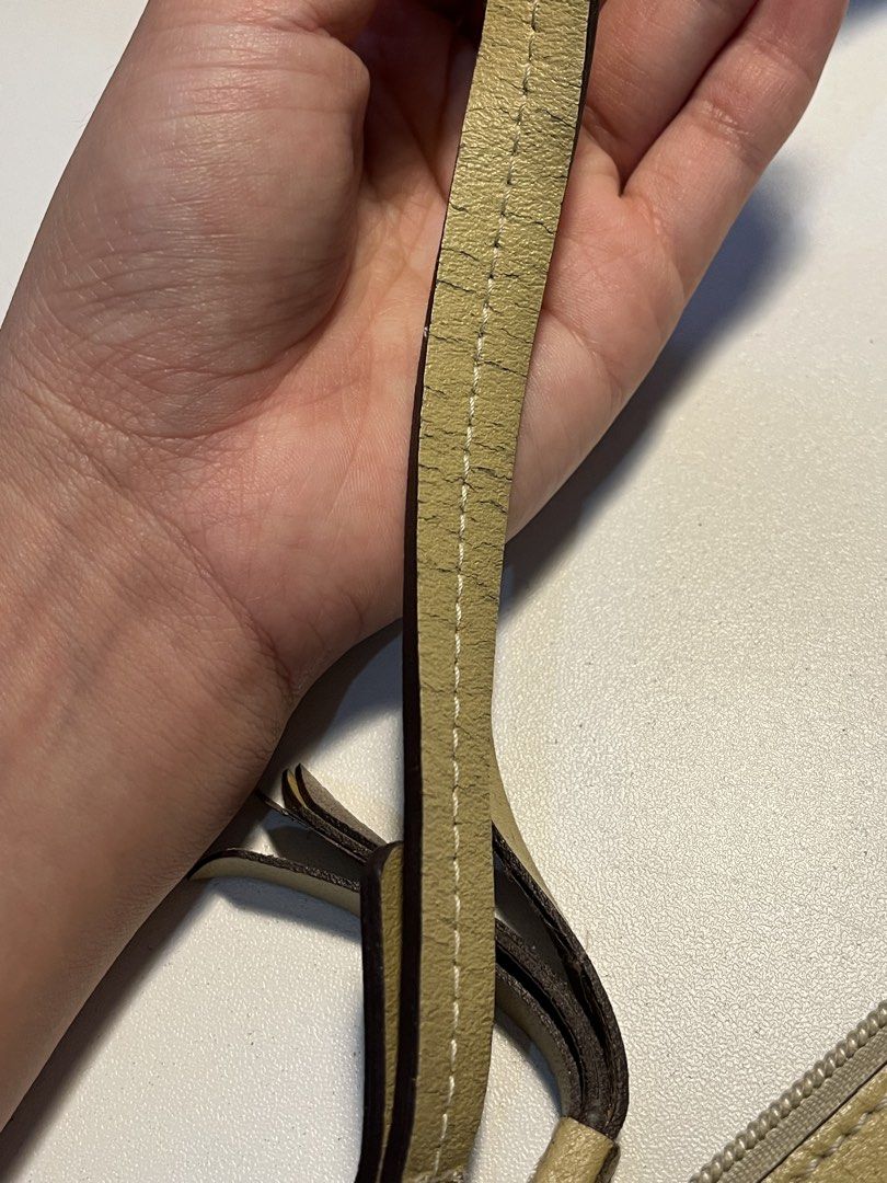 Dunlop Beige Shoulder Bag (Category: Shoulder Bags) located in Quezon City. Submitted by juliacassandr4a (Listing ID 1465118749, Image 3). Description: - Brand/Model: Dunlop beige shoulder bag - Design: Short strap, fringe zipper pull, and top zip closure - Interior: Includes built-in card slots and a zippered pocket - Condition Notes: Noticeable cracking on the strap material, fading on the Dunlop logo, and staining on the inside lining near the